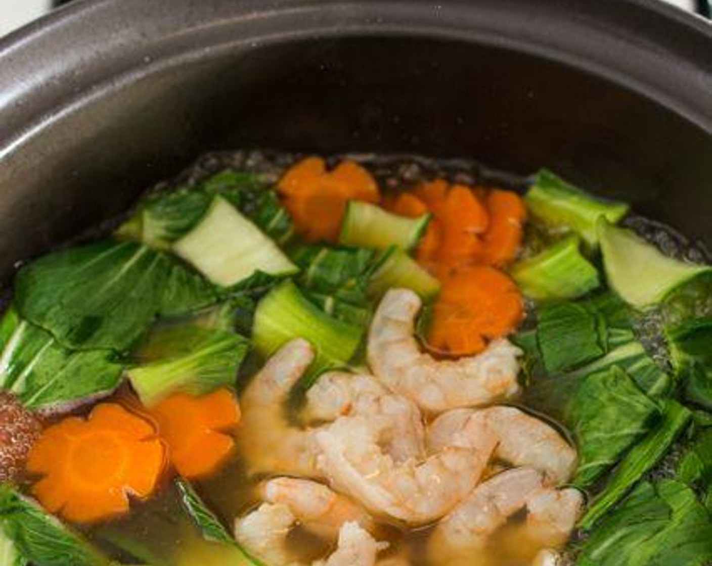 step 3 Bring Chicken Stock (4 cups) to a boil over medium-high heat. Add Carrot (1). Add Soy Sauce (1 tsp), Shaoxing Cooking Wine (1 tsp) (if using) and Salt (1/2 tsp) to the soup. Add Baby Bok Choy (2 stalks) to the soup. Bring the soup to a boil again, then add the Medium Shrimp (8). Let the soup boil for a few seconds, turn off the heat and cover the pot.