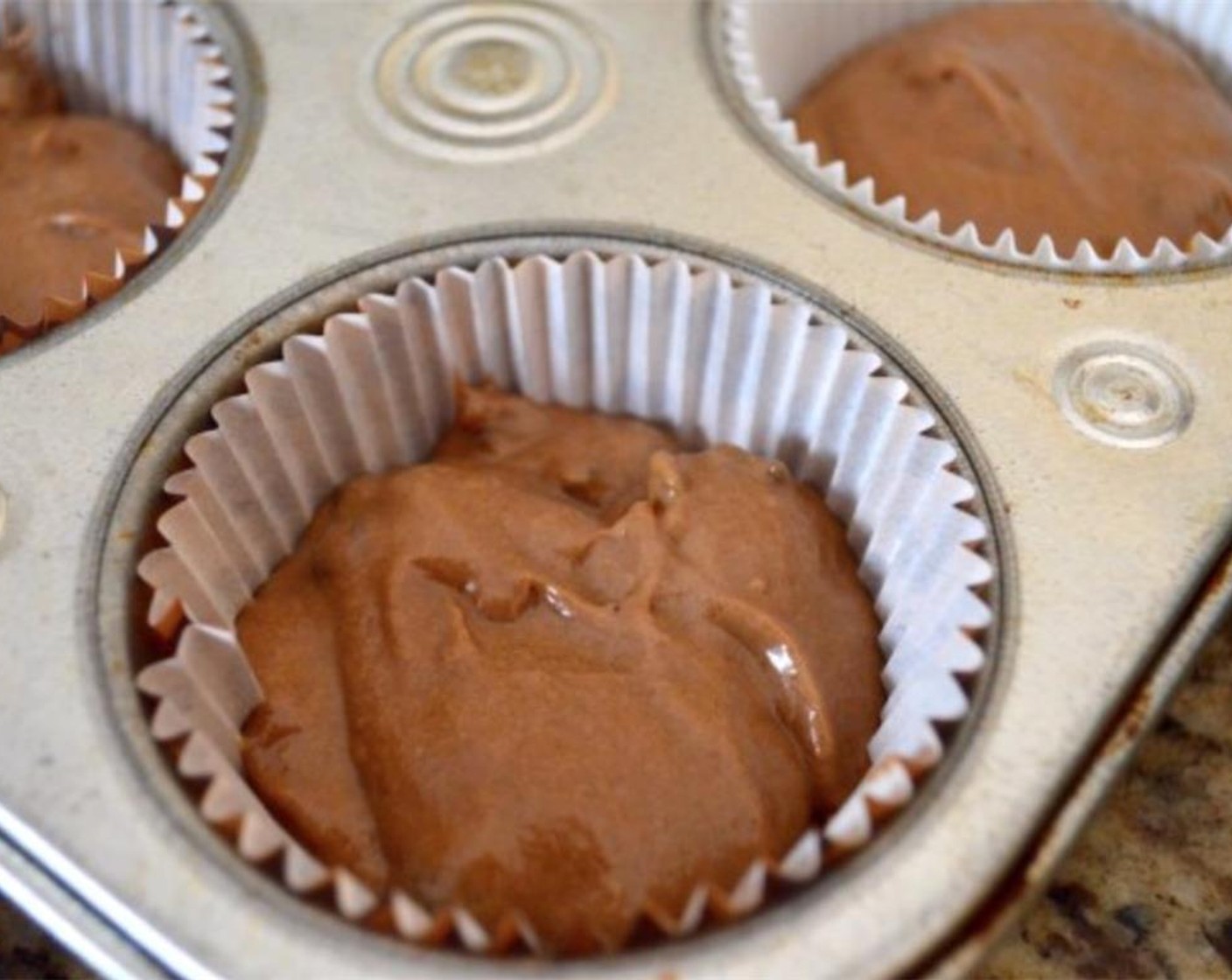step 6 Use a 1.5 inch cookie scoop to distribute two scoops of the batter into each lined muffin well.