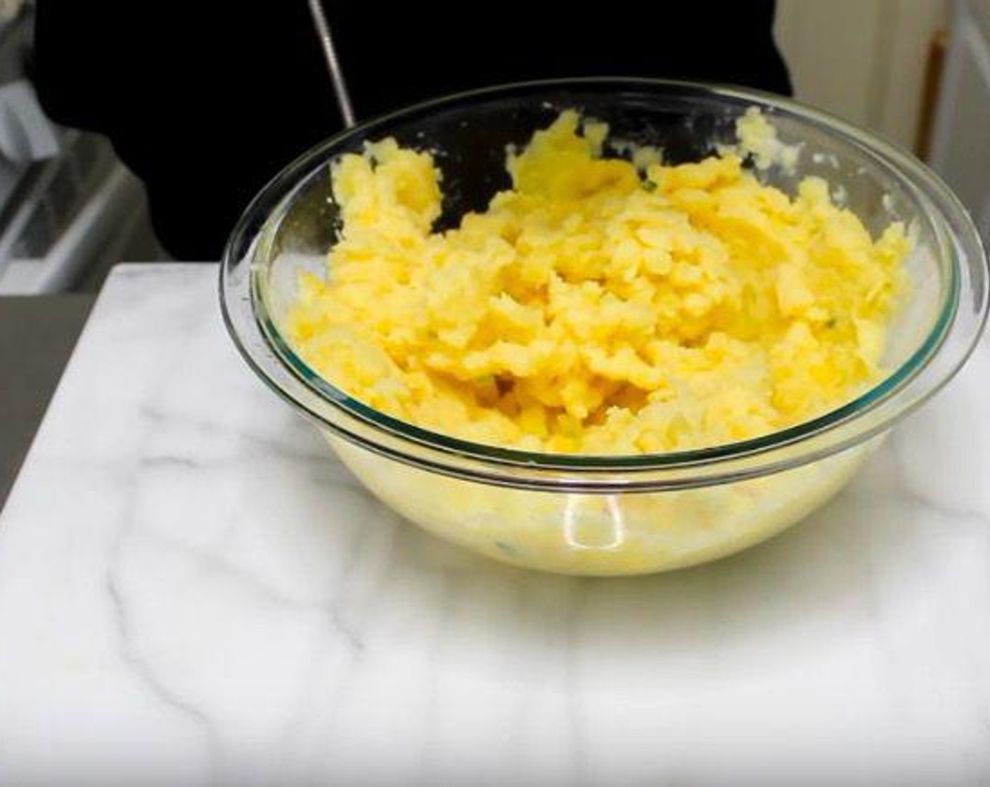 step 2 In a mixing bowl, add cooked Potatoes (2 lb). Pour in the butter and milk mixture a bit at a time, mashing the potatoes as you go.