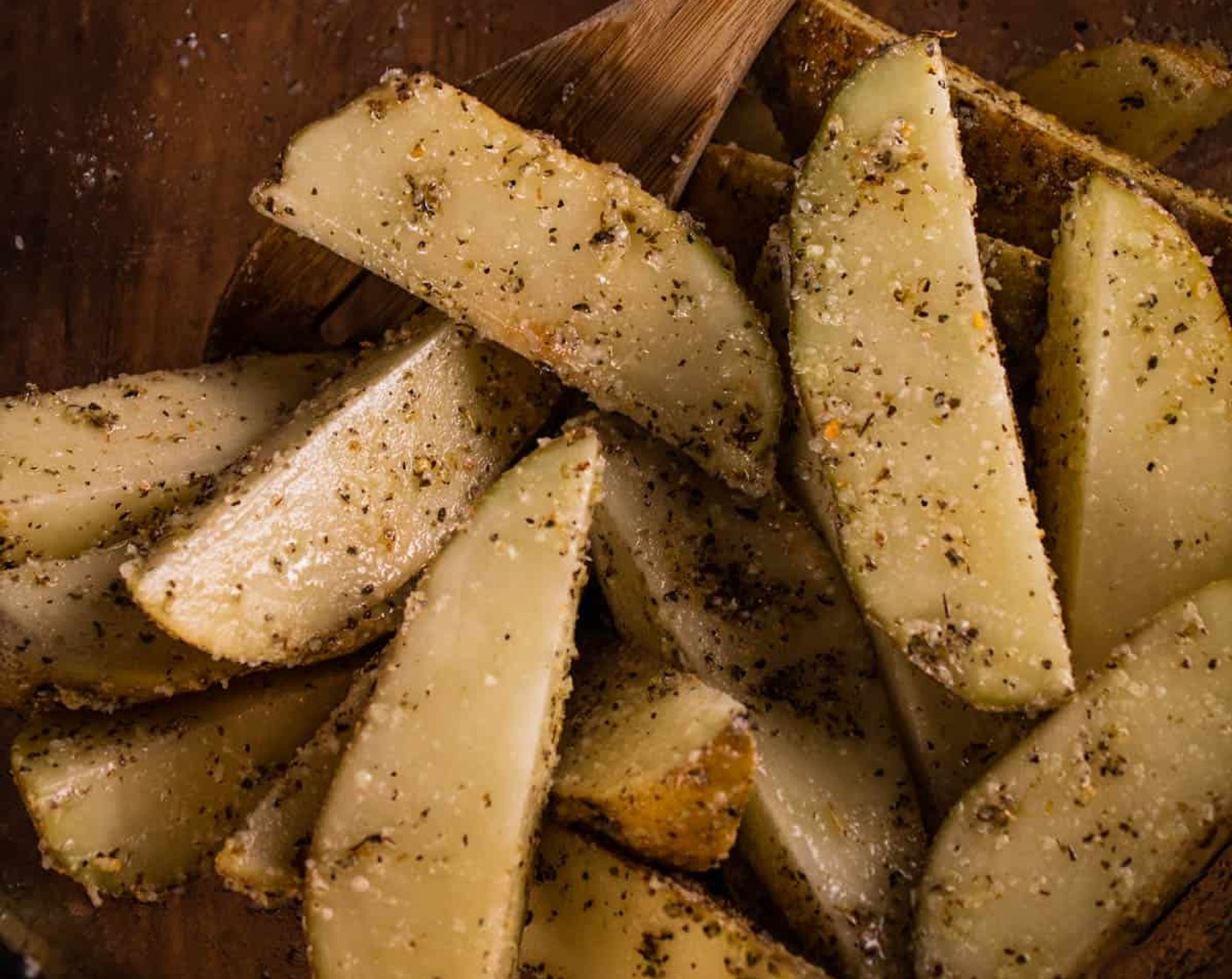 step 3 Place potato wedges in a large mixing bowl and add Olive Oil (1/4 cup), Grated Parmesan Cheese (1/4 cup), Italian Seasoning (1 Tbsp), McCormick® Garlic Powder (1 tsp), and Kosher Salt (1/2 tsp). Toss to combine until the olive oil and seasonings are well coated on all of the potato wedges.