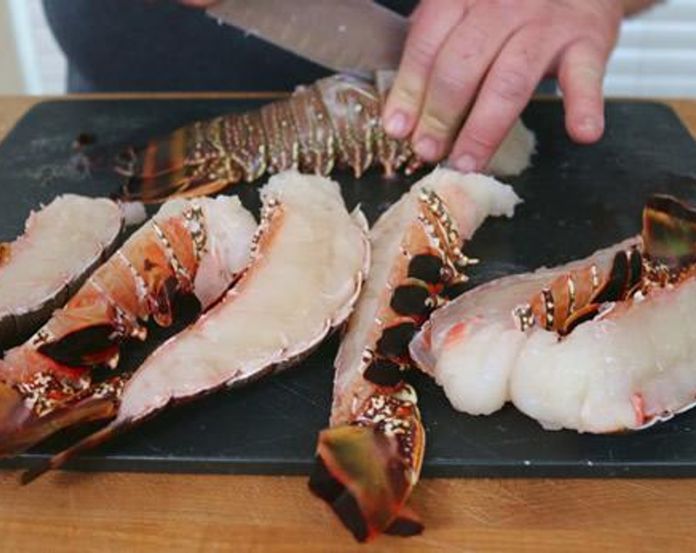 step 2 Split Lobster Tails (4) in half length-wise and season with Kosher Salt (1 Tbsp), Freshly Ground Black Pepper (1 Tbsp), and Olive Oil (1/4 cup).