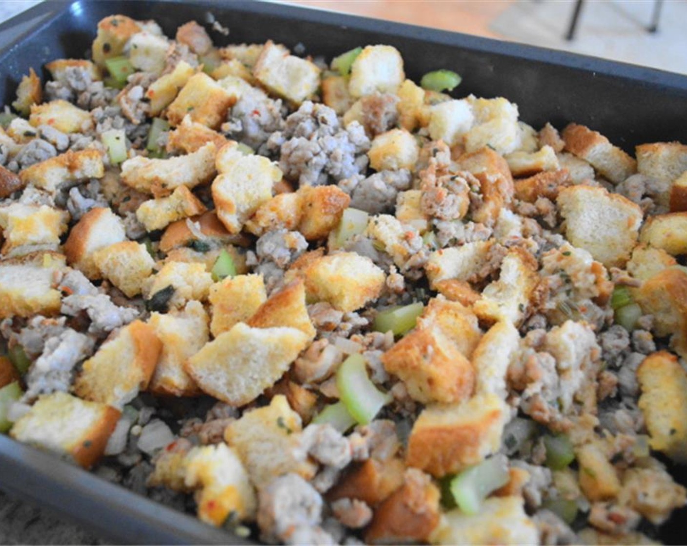 step 6 Once cooled, pour the sausage mixture into the baking pan with the toasted bread, then add the Garlic (2 cloves) and Low-Sodium Chicken Stock (2 1/4 cups). Mix everything well in the baking pan and gently press it so that it becomes even on top, then cover it and refrigerate it overnight.