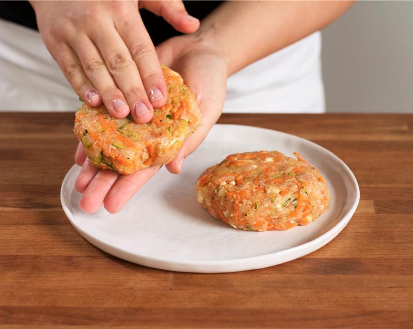 step 7 Place Ground Turkey (8 oz) into the medium bowl with the carrot zucchini mixture. Add Salt (1/2 tsp), Ground Black Pepper (1/4 tsp), and Crumbled Feta Cheese (2 Tbsp). Form the mixture into two equal sized patties.