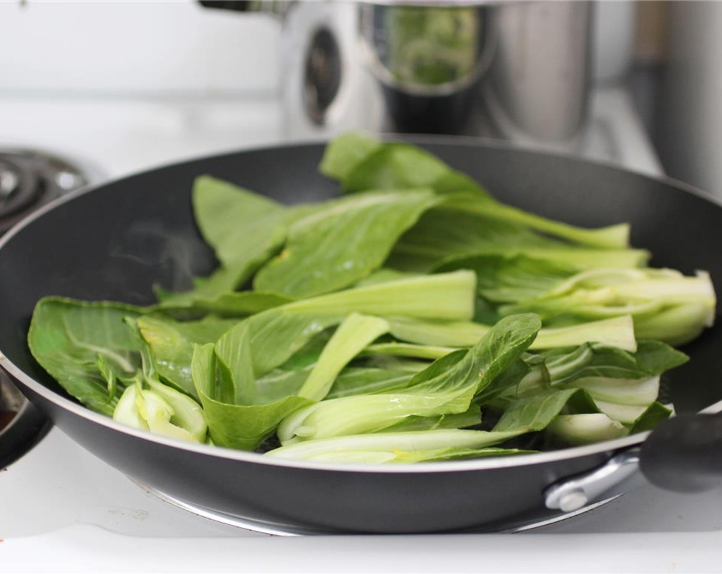 step 9 While the tofu is broiling, heat the Sesame Oil (1/2 Tbsp) in a skillet at medium to medium-high heat. Add the Baby Bok Choy (2 bunches) and sear just until the leaves are wilted – this will keep a bit of texture on the stems.