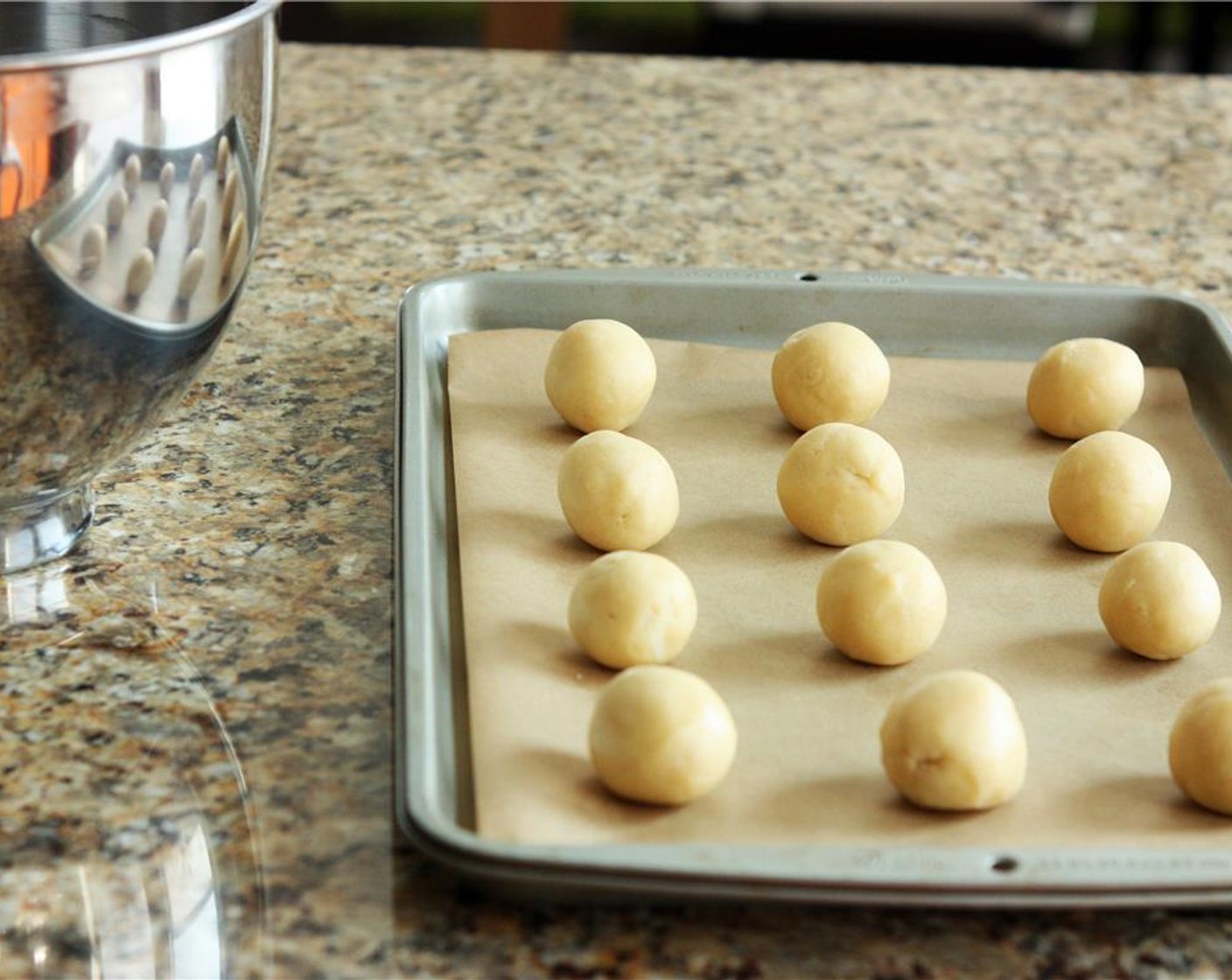 step 6 Remove dough from the refrigerator. Discard plastic wrap. Form 12 balls, each about 1 1/2″ inches in diameter. Use the palms of your hands to form them into balls. Space evenly on the baking sheet, leaving about two inches between them.