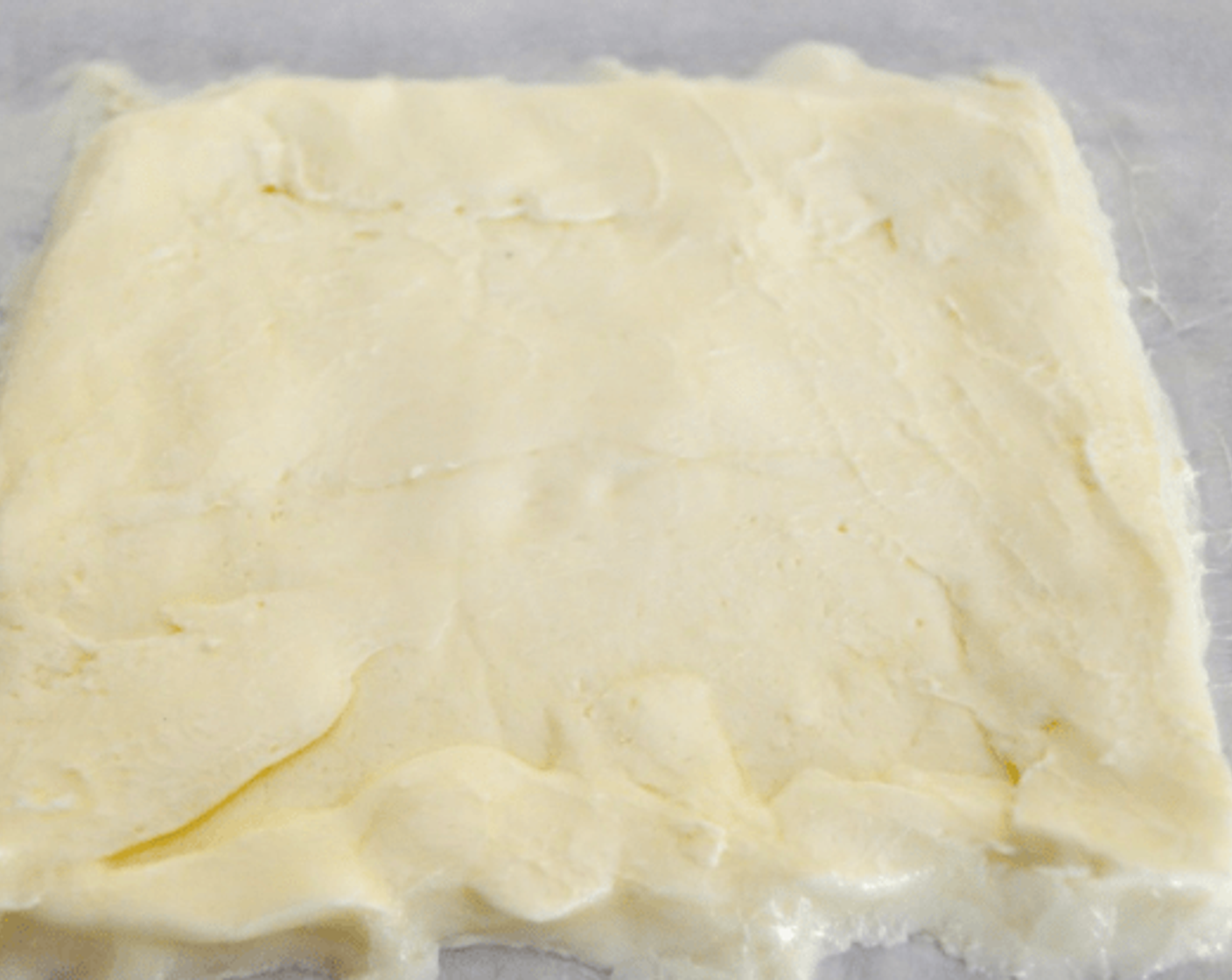 step 6 Take the block of butter and put it diagonally onto the middle of the square of dough so that a side of the butter faces a corner of the dough. Bring the corners of dough over the butter to completely envelope it. Roll it out into a 16 x 8 rectangle.