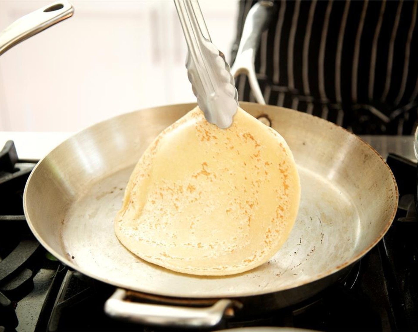 step 12 Heat another medium saute pan over medium high heat. Place one Naans (4 pieces) into hot pan and heat for one minute on each side. Repeat with each piece of naan. Fold each piece in half, then fold in half again. Hold for plating.