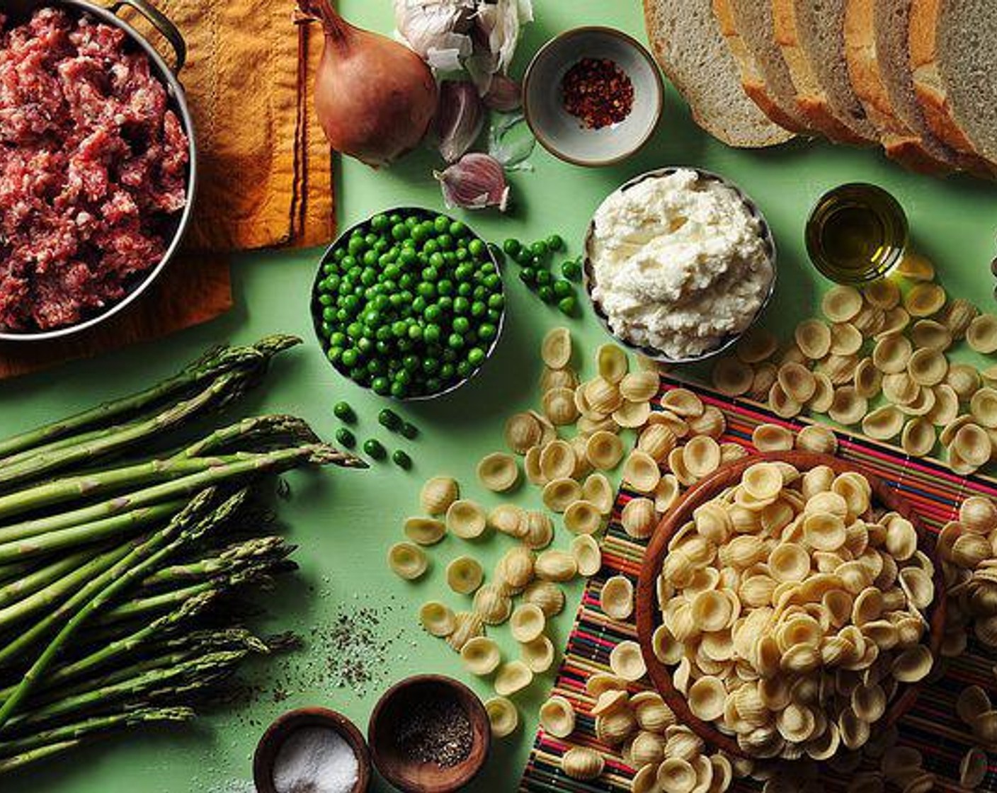 step 2 Mince the Garlic (3 cloves) and Shallot (1). Cut the Asparagus (3 cups) into 1-inch pieces. Remove the casings from the Spicy Sausage Link (1 lb). Thaw the Frozen Green Peas (1 1/2 cups) Grate the Parmesan Cheese (1/2 cup).