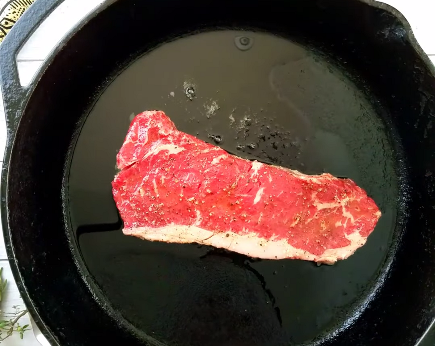 step 3 Heat up the cast iron pan to high temp, add Extra-Virgin Olive Oil (1 Tbsp) and lay the sirloin steak into the pan. Listen for the sizzle. Once you’ve put it in. don’t move it around for at least 3 minutes, then flip it over.
