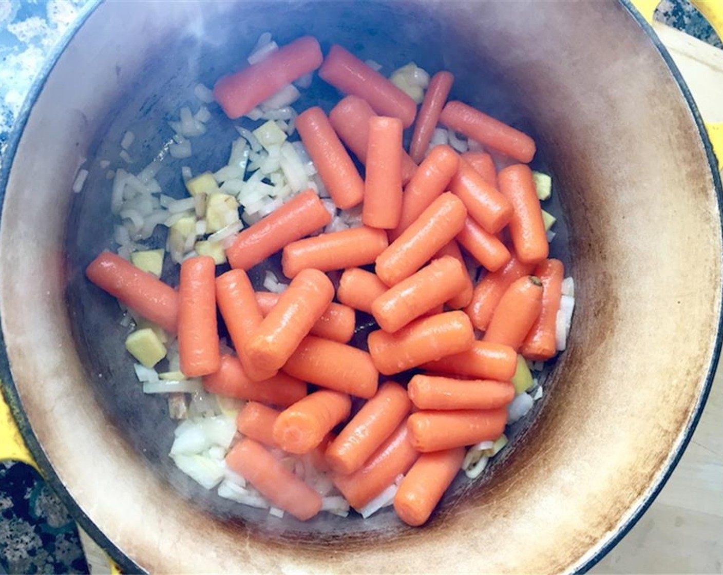 step 1 In a soup pot, sweat Sweet Onion (1/2) and Fresh Ginger (2/3 cup) until the onion is translucent, about three to five minutes. Add the Baby Carrots (3 1/2 cups) and cook a few minutes more.