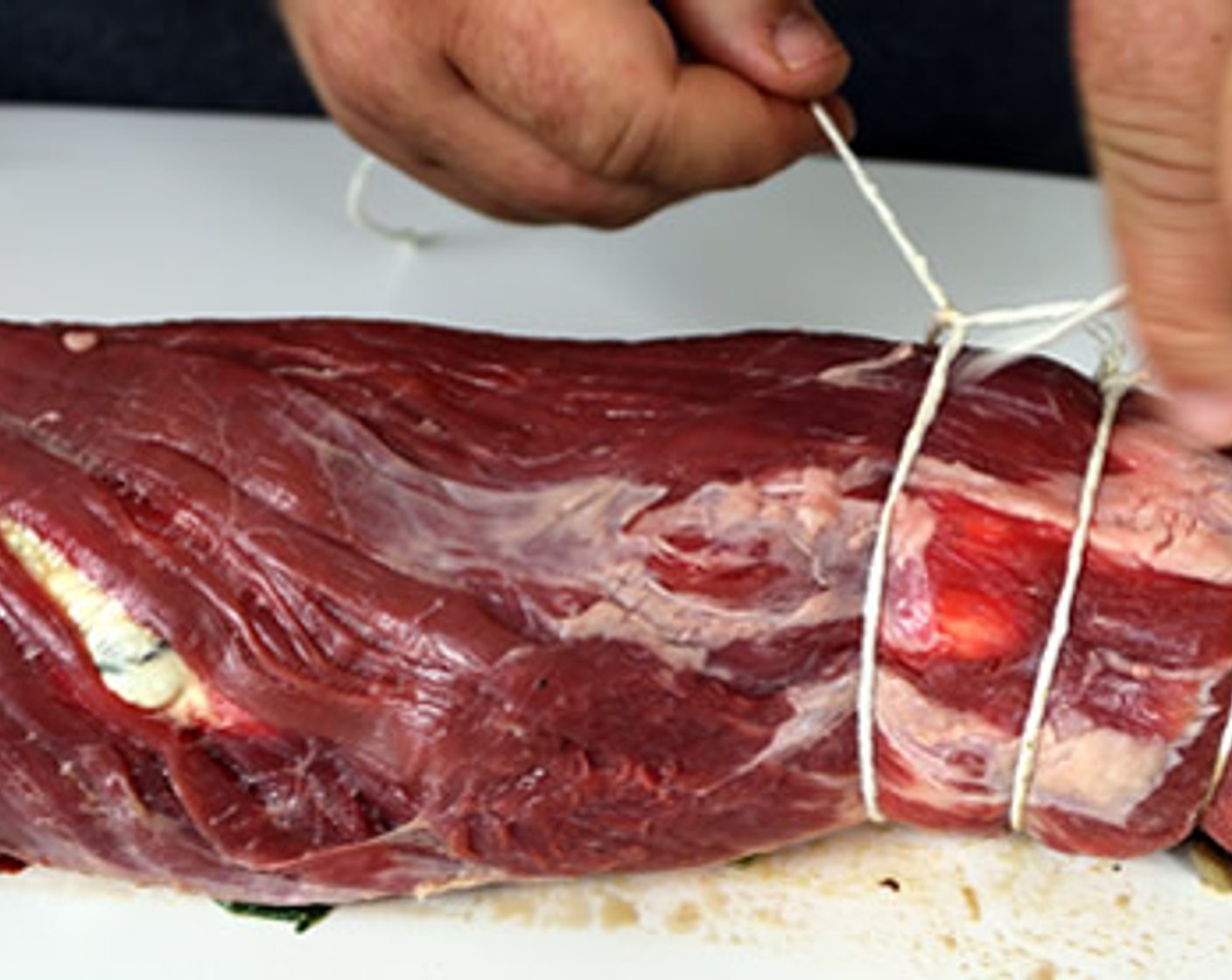 step 7 Use 16-inch pieces of butcher twine to tie the flank steak spacing each string out about 1 inch.