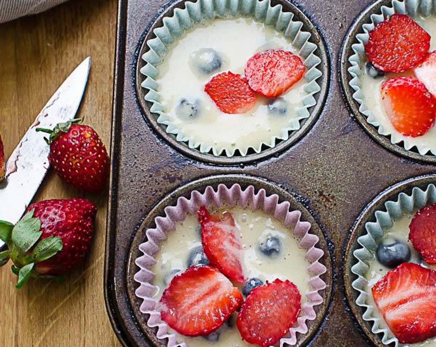 step 6 Spoon the batter into the prepared muffin cups. Top the muffins with Fresh Strawberry (1 cup) and mound the streusel on top of the berries.