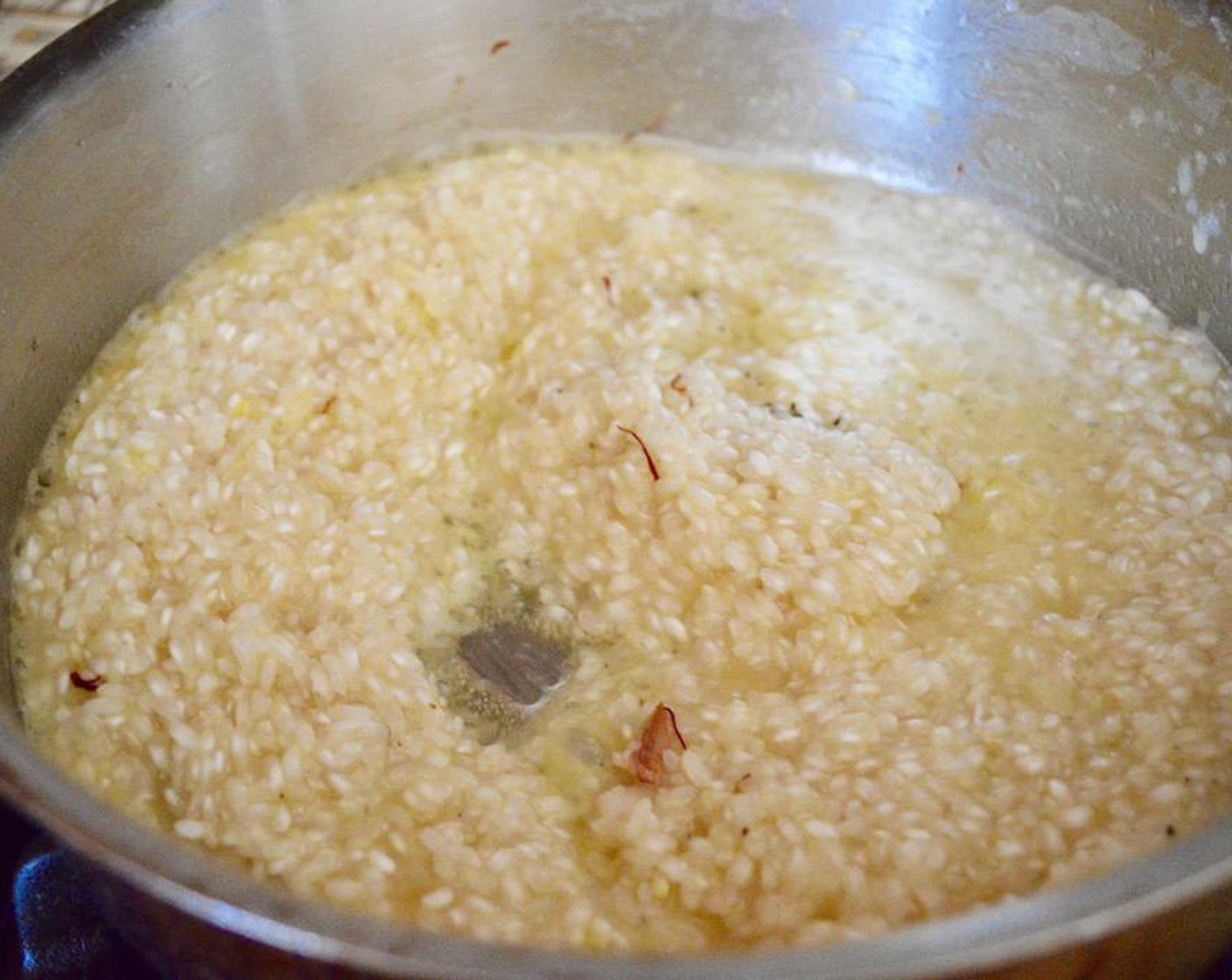 step 5 Add Arborio Rice (1 1/2 cups) to the skillet with melted butter and let it toast for a minute. Pour in White Wine (3/4 cup) and let the rice completely absorb it. Stir often. Season with Saffron Threads (1 pinch), Dried Tarragon (1 pinch), Salt (1 pinch) and Freshly Ground Black Pepper (1 pinch).