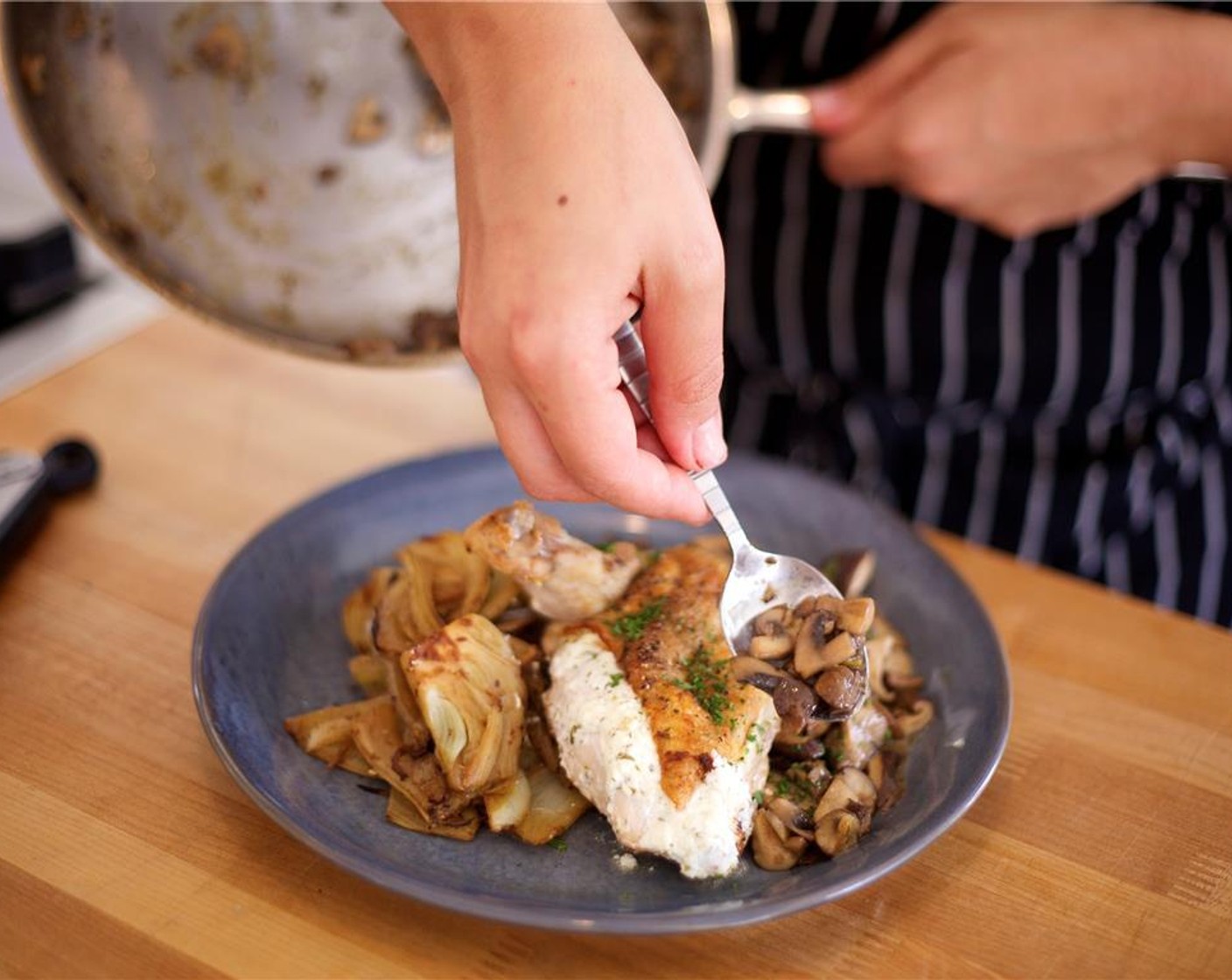 step 23 Place the fennel bulb in the center of two plates. Evenly spoon the mushrooms with sauce next to the fennel on each plate. Lay the chicken breast on top of the fennel and mushrooms. Sprinkle remaining parsley on top of the chicken to garnish.