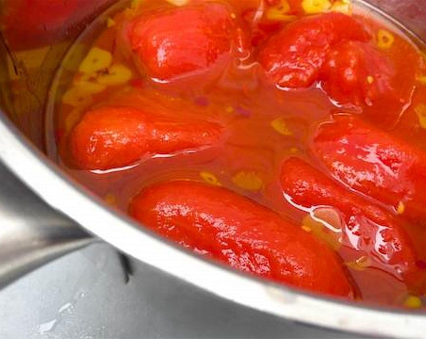 step 2 Pour in the Whole Peeled Tomatoes (1 can), mash them up a little, and cook them in the hot oil for 7 minutes.