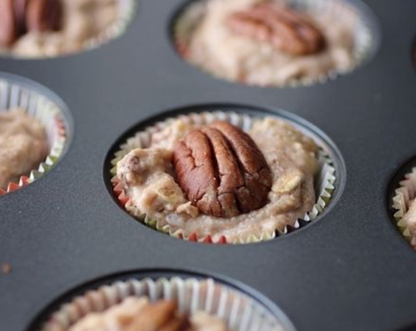 step 5 Place paper liners in the muffin tins or grease the muffin tins. Fill the tins about 3/4 of the way full with batter and top the muffins with Pecans (35).