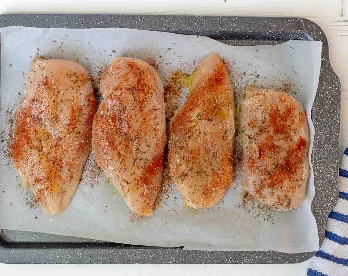 step 4 Place Boneless, Skinless Chicken Breasts (5) on the prepared baking sheet. On top of each chicken breast drizzle a little olive oil and sprinkle with Italian Seasoning (to taste), Garlic Salt (to taste) and Paprika (to taste). Use your hands to spread olive oil and seasonings evenly over the top of chicken breasts.
