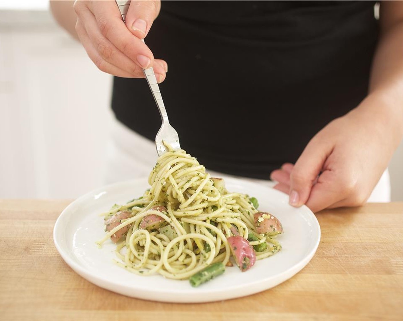 step 10 Place the spaghetti in the center of two plates. Garnish with the remaining parmesan, pine nuts, and lemon zest.