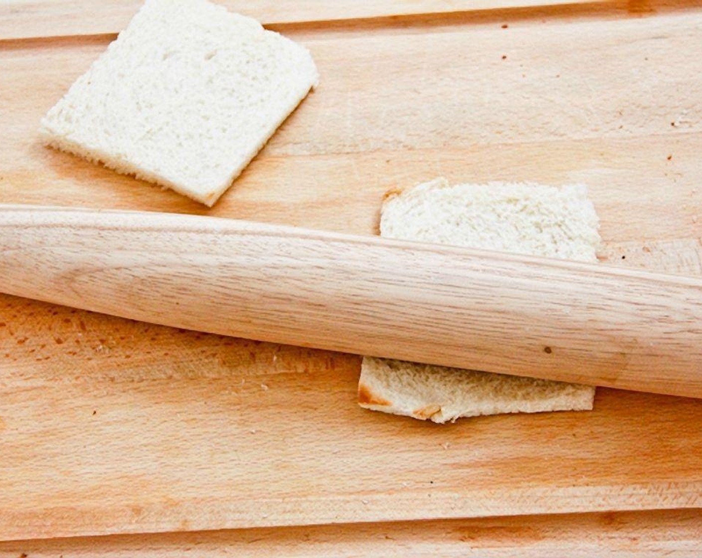 step 2 Roll the bread slices flat with a rolling pin, wine bottle or just flatten the bread with your hands.