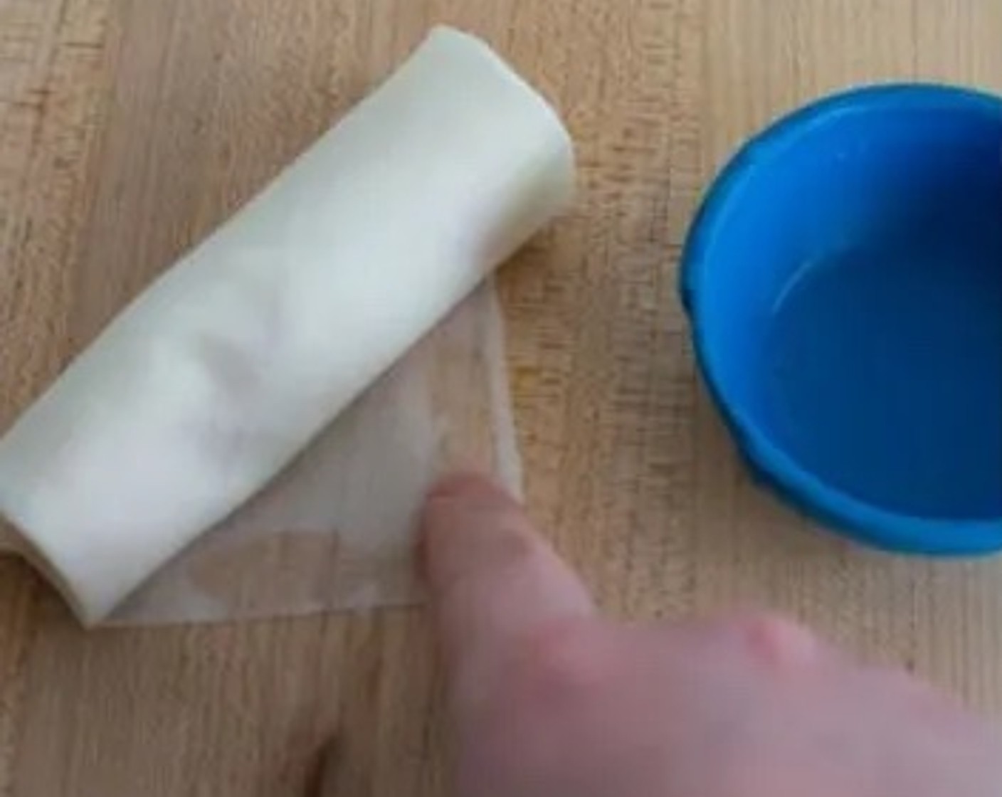 step 5 Dip your finger into some water and spread it on the top edge of the wrapper to create a seal, then finish rolling.
