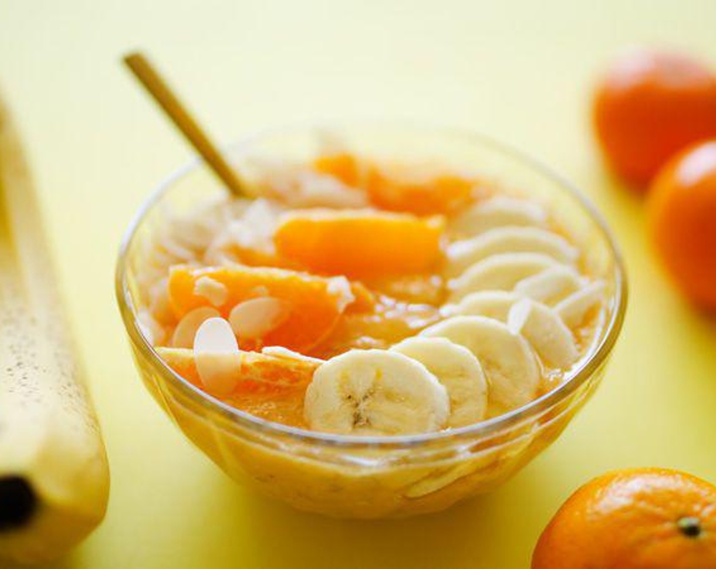step 2 Pour smoothie into a serving bowl and top with segmented mandarin oranges, sliced banana, and shaved almonds.