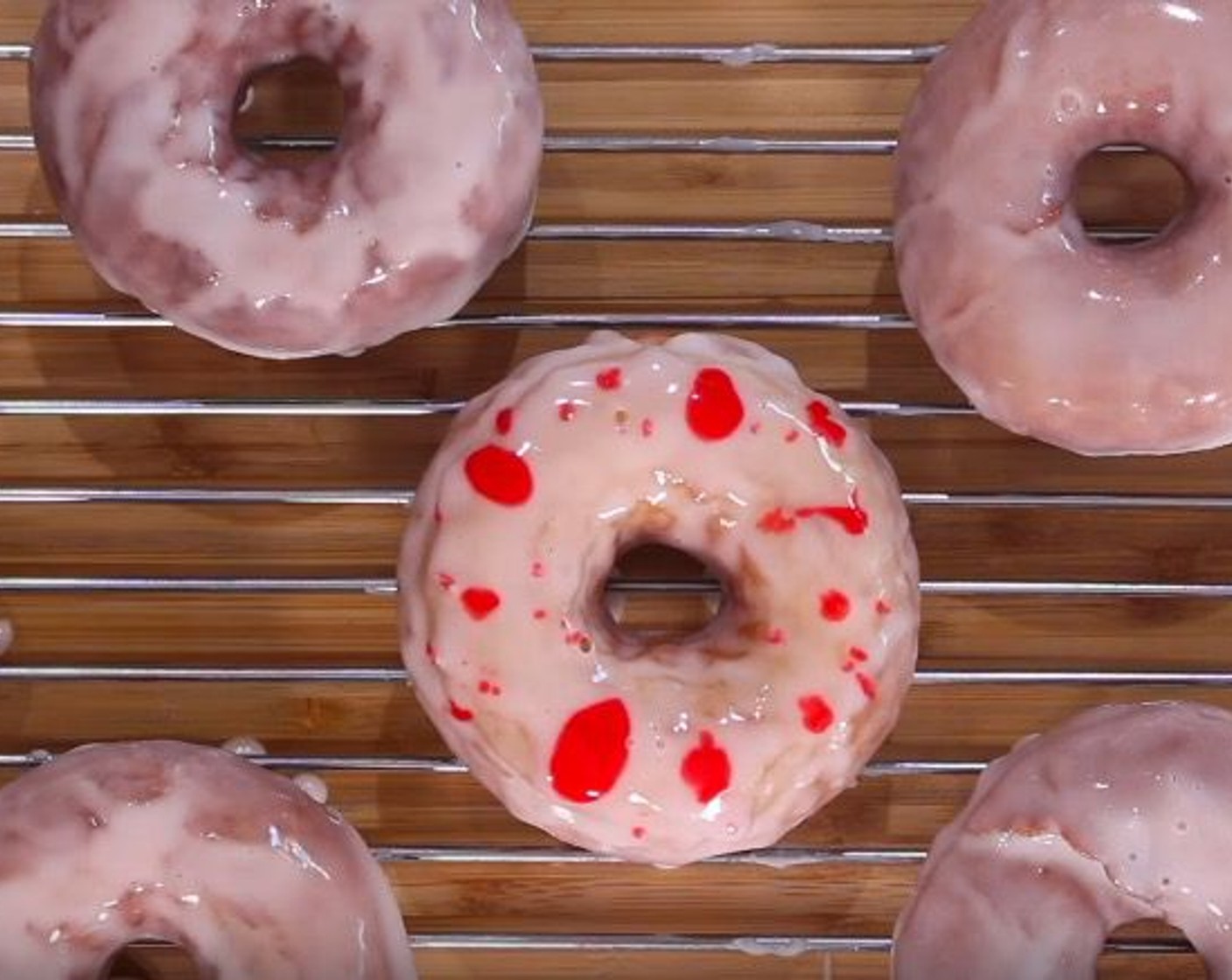 step 14 Dip a gumball into the white icing. Draw an eye using Chocolate Frosting (to taste). Using a toothpick or skewer, dab dots of the red glaze over to create a splatter effect.