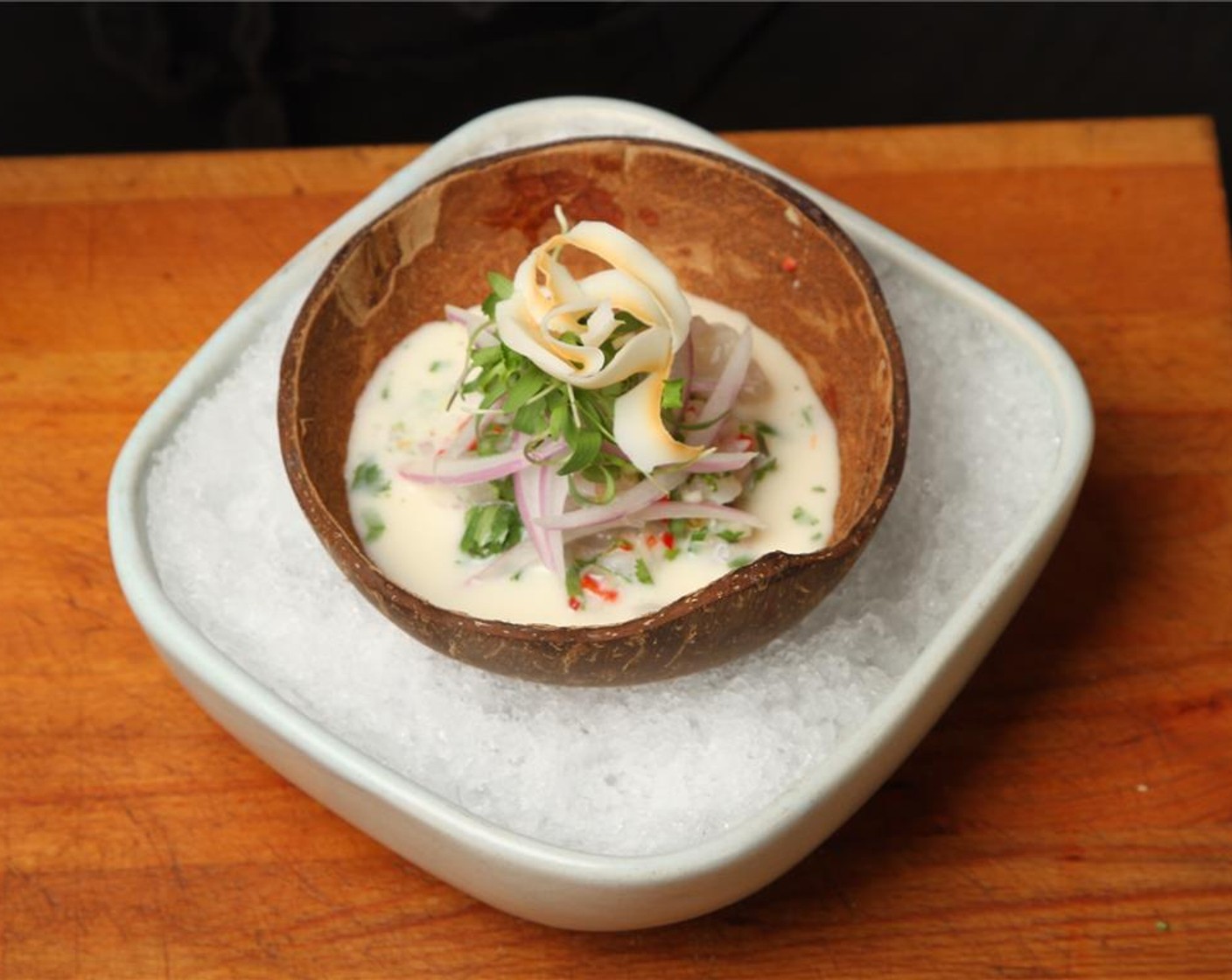 step 10 Spoon the fish making sure that it's covered with the coconut marinade. Top it with the sliced red onion and baby coriander. Finish with the Coconut Shavings (to taste) and enjoy!