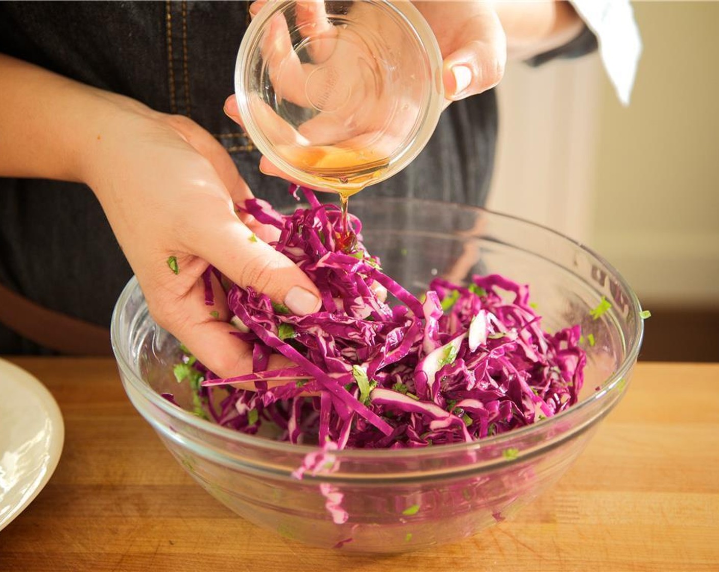 step 16 Juice Lime (1) into a medium bowl and combine with remaining Maple Syrup (1/2 Tbsp), Sesame Oil (1 tsp), and Salt (1/4 tsp). Gently fold in the sliced Red Cabbage (2 cups) and fresh cilantro until ingredients are evenly coated.