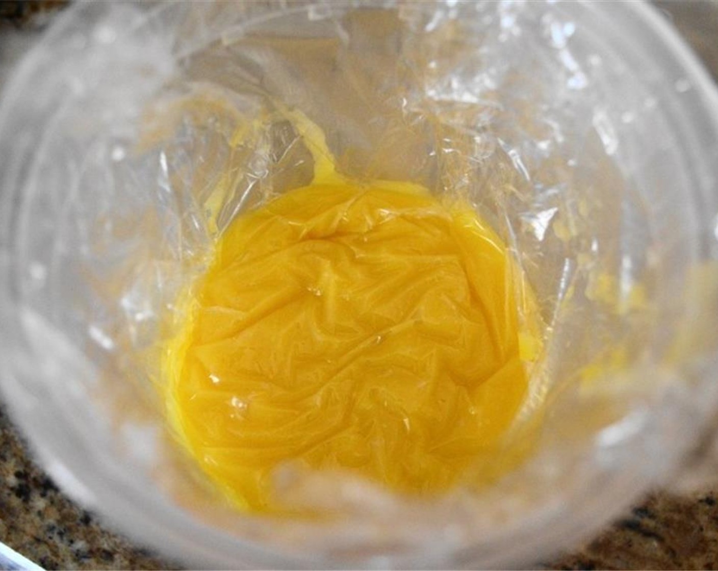 step 7 Spoon it into a clean container. Cover the lemon curd with plastic wrap right on top of it so that it doesn't develop a skin, then seal the container with its top. Let the lemon curd chill for at least 3 hours before using it in countless ways!