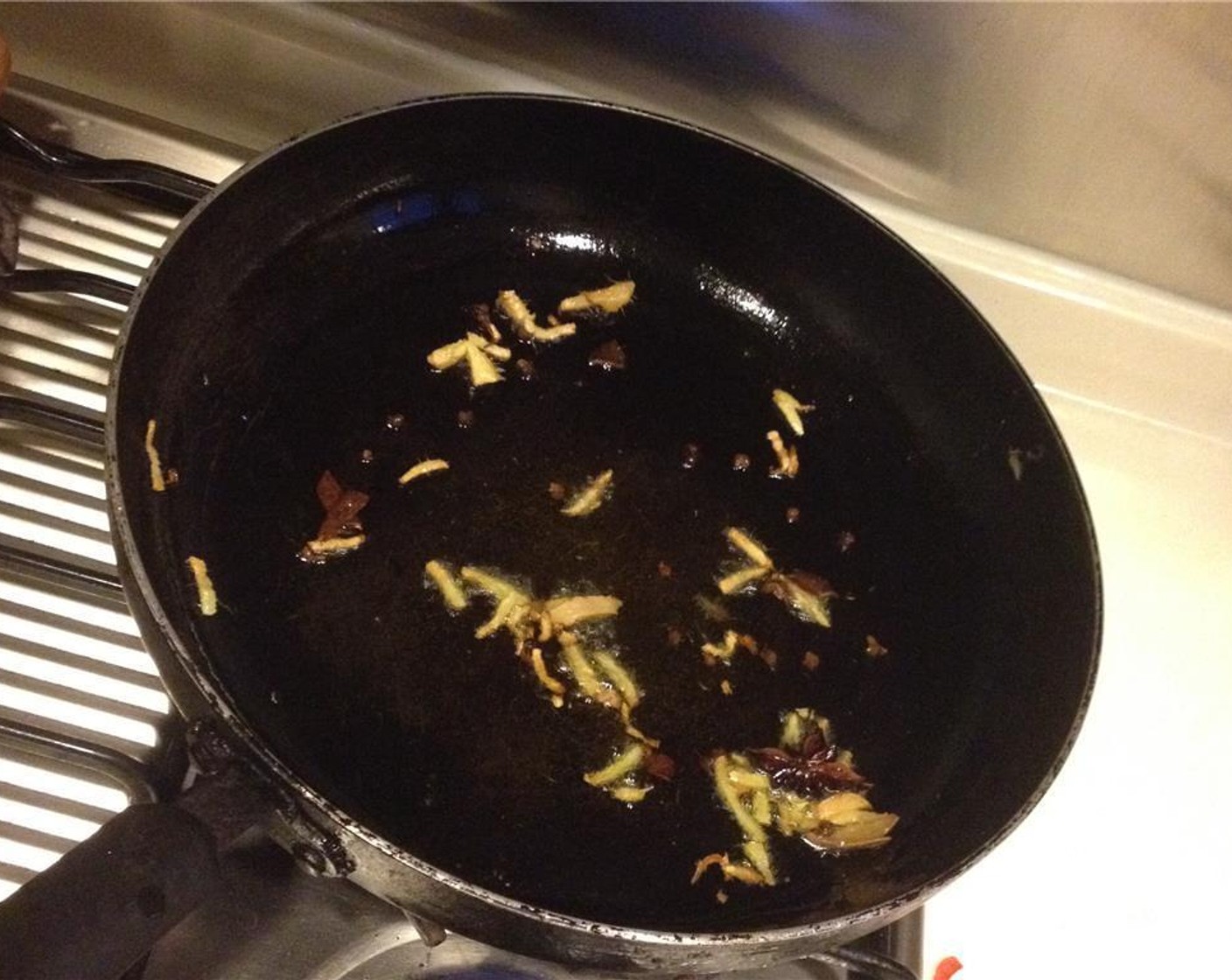 step 4 In a pan, heat the Vegetable Oil (2 Tbsp) over high heat. Cook the Fresh Ginger (1 in), Scallions (to taste), Chinese Red Pepper (1 handful), Cinnamon Stick (1), Star Anise (2), Bay Leaf (1), and Dried Chili Peppers (3) until fragrant.