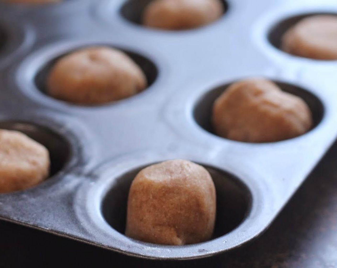 step 4 Roll pieces of cookie dough in to 2-3 inch balls. Place them into the muffin pan and bake for 10-12 minutes.