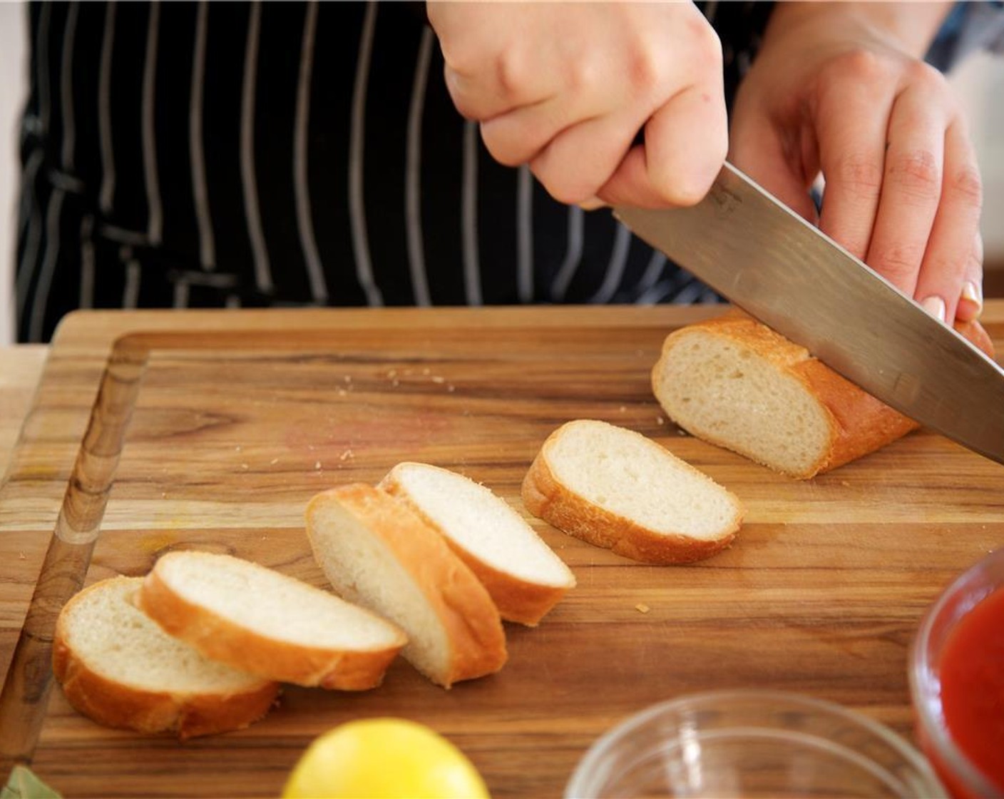 step 2 Slice Baguettes (2) on a bias into eight one inch thick slices. Drizzle a small amount of olive oil onto each piece of bread and place on a baking sheet. Peel Carrot (1) and dice into quarter inch pieces. Peel and chop Onion (1) into quarter inch pieces.