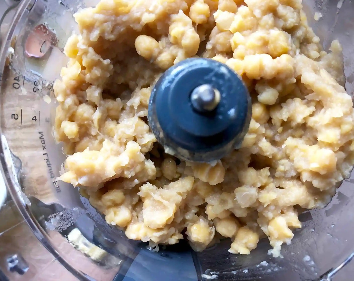 step 4 Drain the chickpeas. You should have roughly 3 2/3 cups (600 grams) now. Place the chickpeas in the bowl of a food processor and process until you get a stiff paste. Then, with the machine still running, add the Tahini (1 cup) paste, the juice from Lemons (1 1/4), Garlic (2 cloves), and Salt (1 tsp).