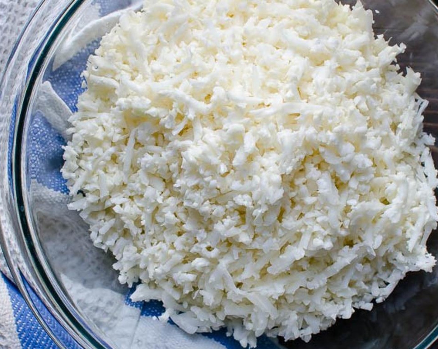 step 1 Cut the Cauliflower (1/2 head) into florets and transfer them into the grater tube of your food processor or use the large holes on a box grater to shred the florets. Set aside.