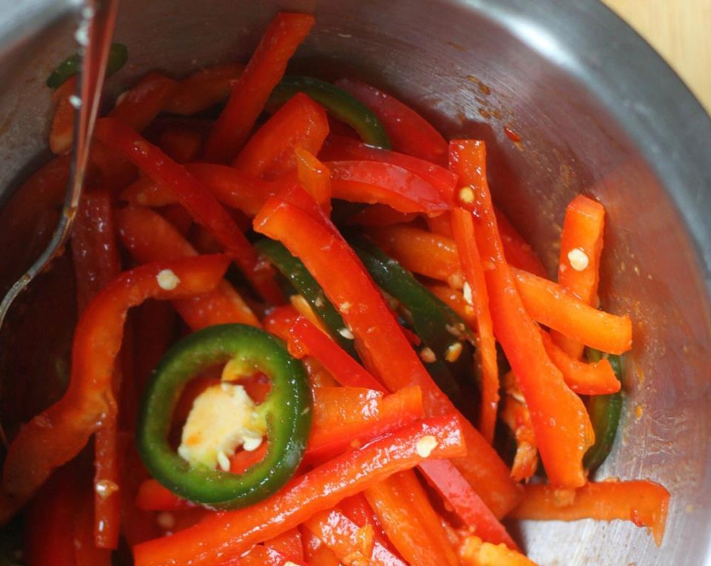 step 4 Toss the Red Bell Pepper (1) and Jalapeño Pepper (1) together with a little sauce as well.
