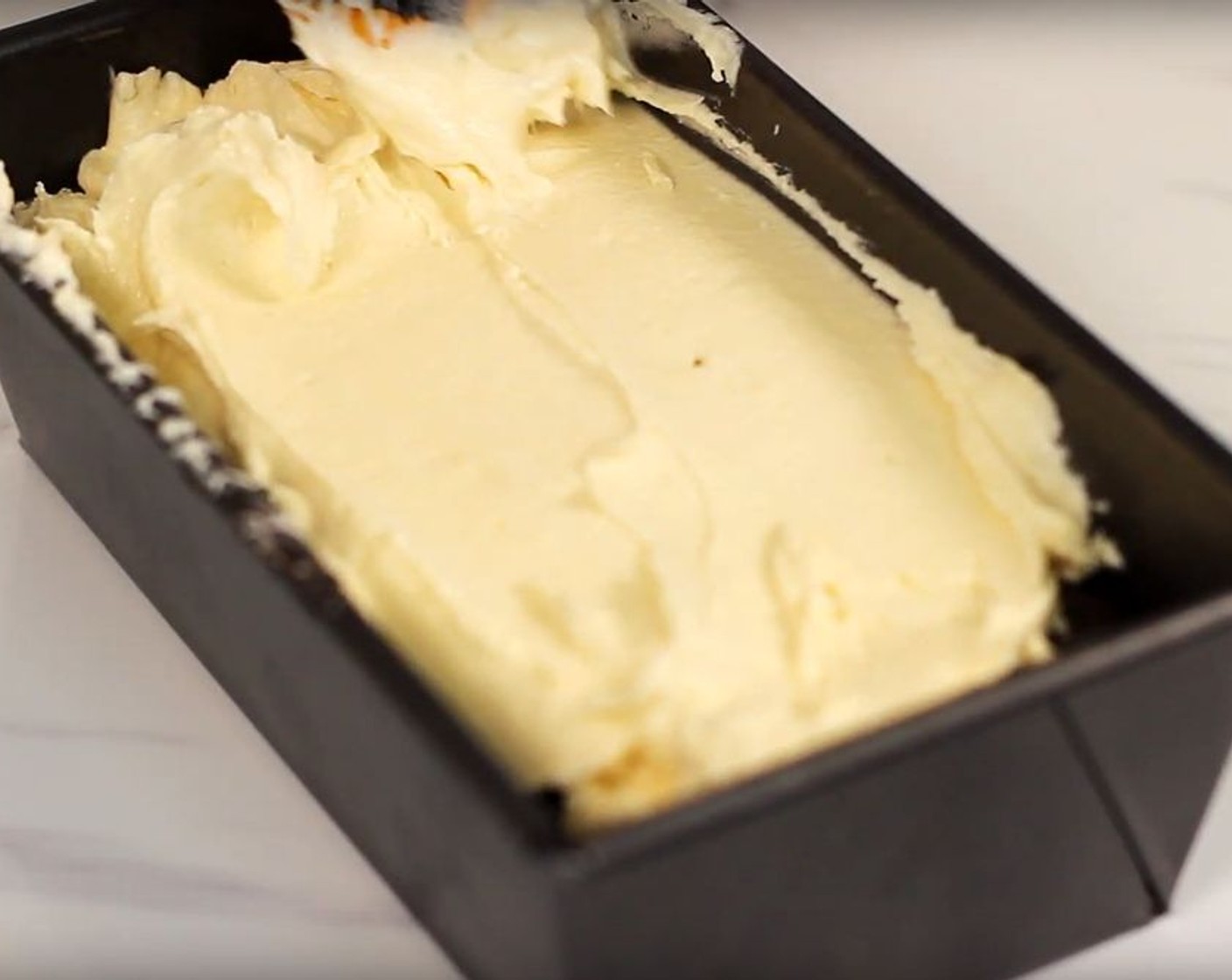 step 8 Transfer half of the vanilla batter into the loaf pan. Then, transfer all of the chocolate batter for the second layer. Cover it with the rest of the vanilla batter as the third layer.