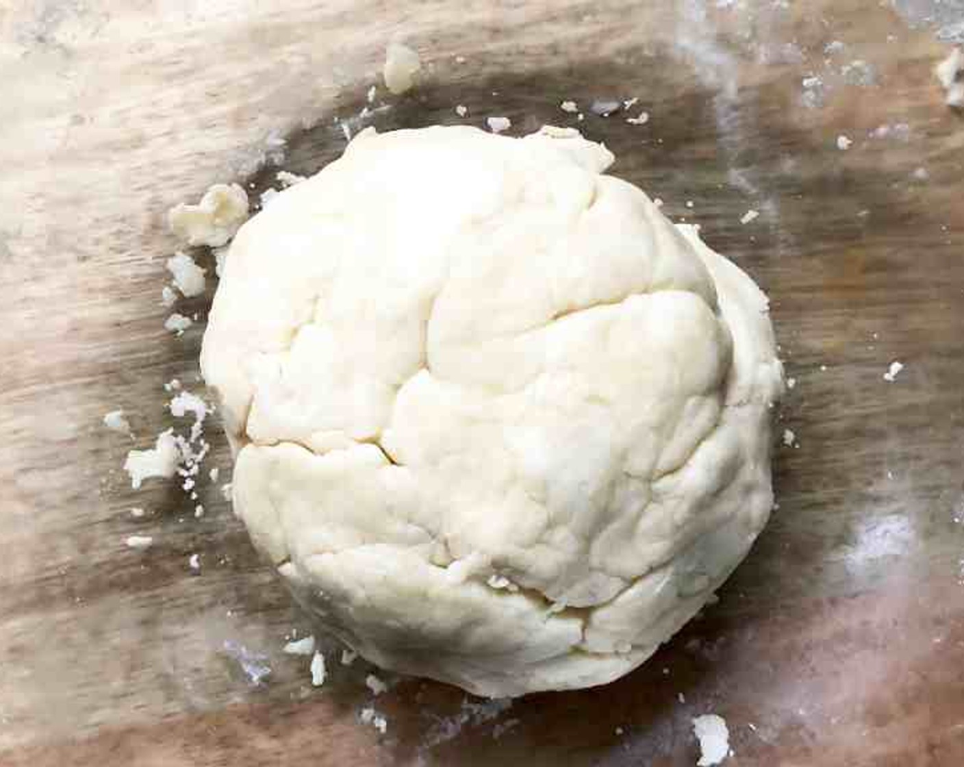 step 3 Moisten a little bit at a time by sprinkling a section with 1 Tbsp of Water (as needed) gently toss with a fork. Push the moistened dough to the side of the bowl. Repeat moistening dough, using 1 tablespoon of water at a time, until all of the dough is moistened. Form the dough into a ball.