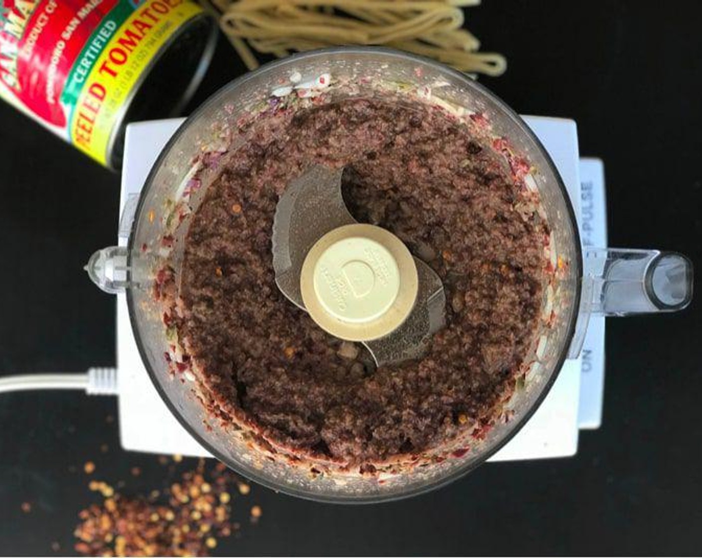 step 3 While you wait, add the Yellow Onion (1), Capers (4 Tbsp), Black Olives (1/2 cup), Anchovy, and Crushed Red Pepper Flakes (1 Tbsp) to a food processor. Process until smooth.
