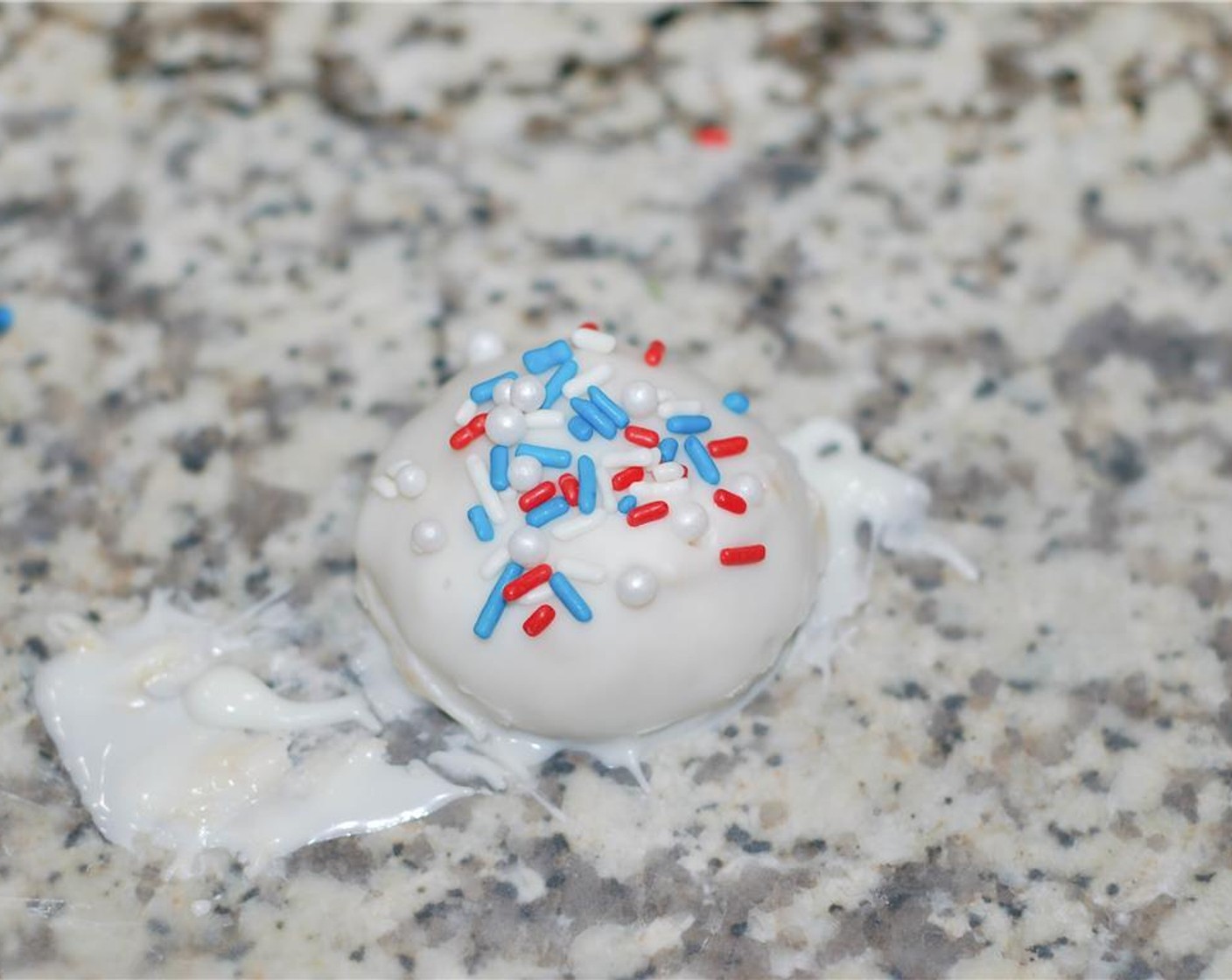 step 8 Place the balls on wax paper, and sprinkle Red, White, and Blue Sprinkles (1/2 cup) and White Sugar Pearl Sprinkles (1/4 cup). Let sit to harden.