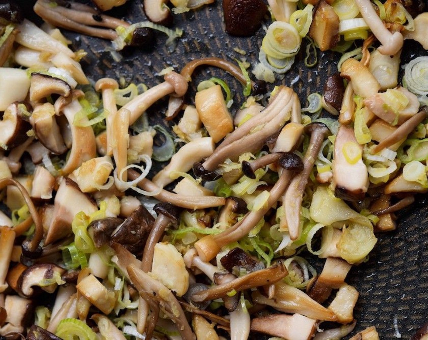 step 2 Once the mushrooms are cooked down, add in the Fresh Ginger (1/2 Tbsp),  Garlic (1 tsp), and Spring Onions (2 Tbsp) and switch off the heat. Season the mushroom mixture with a little Salt (to taste), going easy as the dipping sauce for the dumplings will be salty.