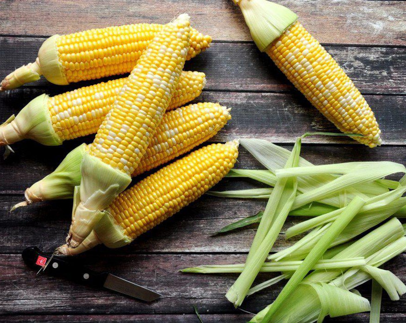 step 2 Make a cut around the Corn (6 ears) husk at 2 inches from the end. Tear off the husk along the cut. This is to make a handle on each corn. Remove the hair inside.