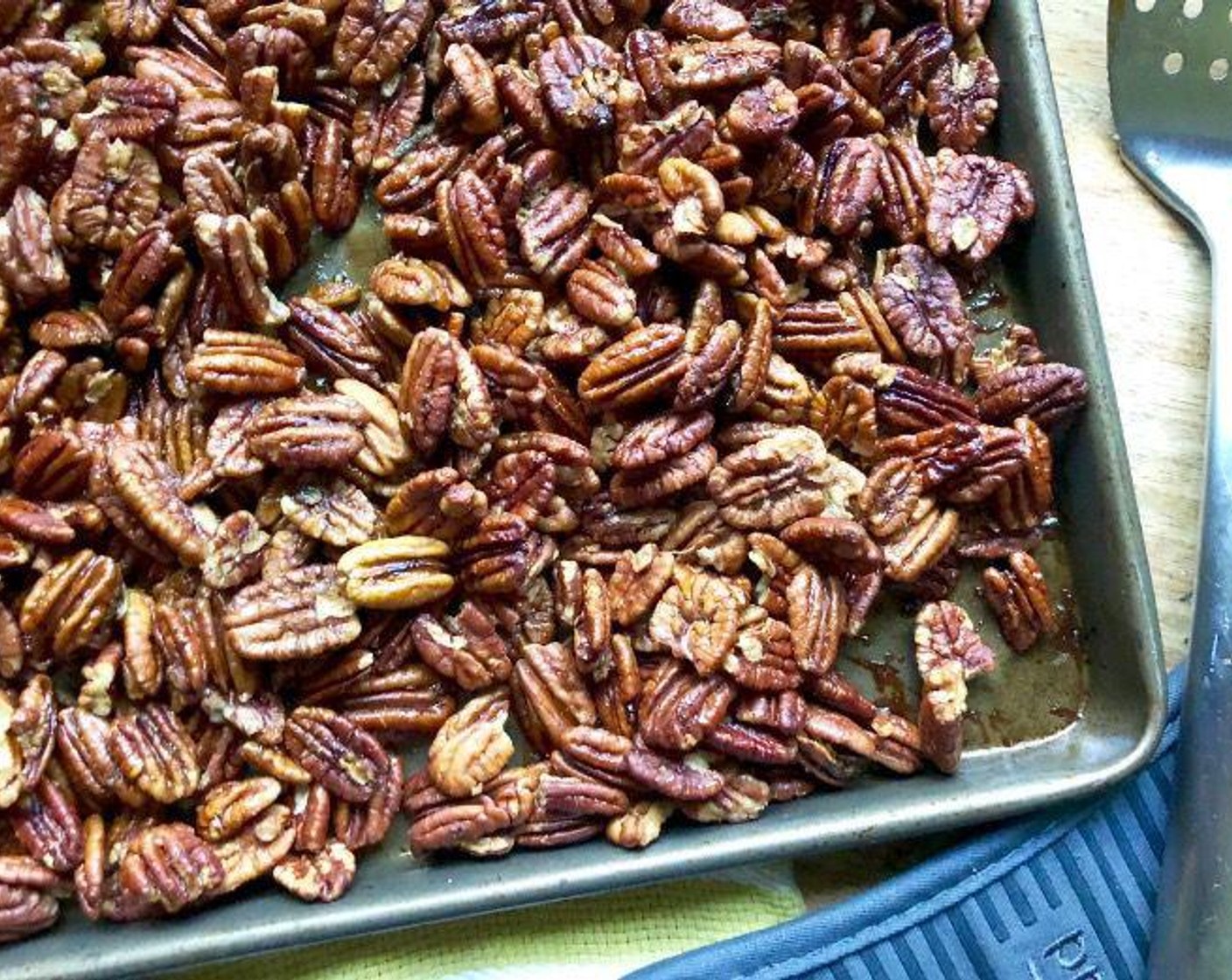 step 5 Spread the pecans in a single layer. Roast for 25 minutes, stirring twice with a large metal spatula until the nuts are glazed and golden brown.