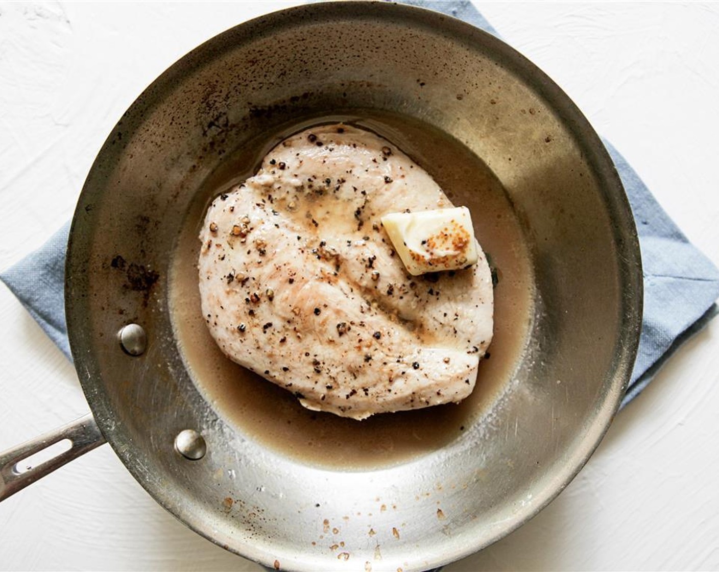 step 4 Heat a small pan over medium-high heat, then add 1 tablespoon of Vegetable Oil (1 Tbsp) and Butter (2 Tbsp). Cook chicken until browned on first side, flip and add Fresh Marjoram (2) and muscadines skins.