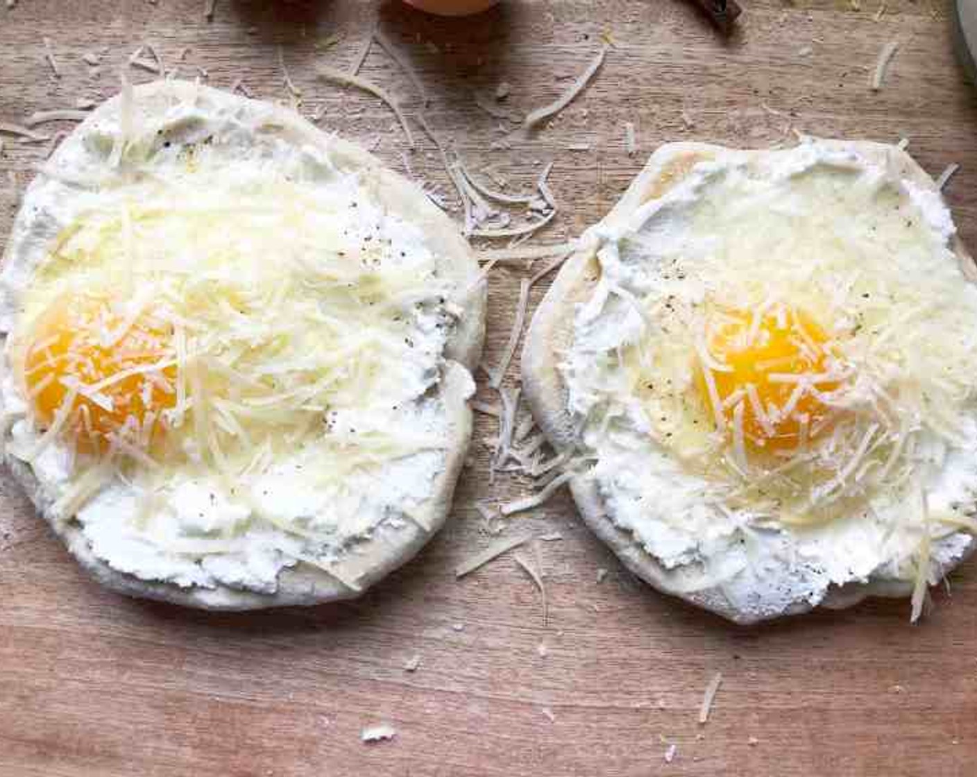 step 7 Sprinkle evenly with Kosher Salt (1/8 tsp), and Freshly Ground Black Pepper (1/8 tsp). Top each dough circle with 1 of the Farmhouse Eggs® Large Brown Eggs (4) and 1 Tbsp of Grated Parmesan Cheese (1/4 cup).