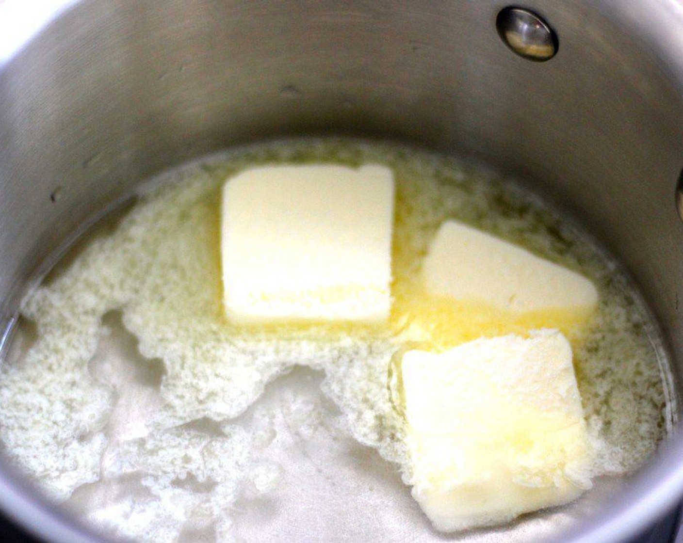 step 2 In a small heavy bottom saucepan on medium heat, add Water (1/2 cup), Unsalted Butter (4 Tbsp), and Granulated Sugar (1 tsp).