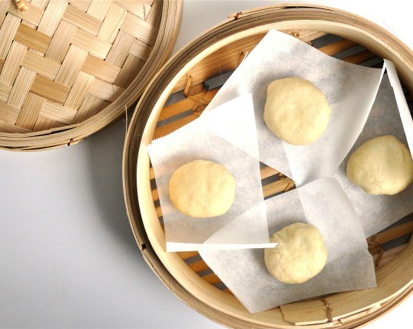 step 11 Fill a large pan with water and bring to a boil. Place steamer over it. Place buns on parchment paper squares and steam for about 15 minutes. Buns will expand, so leave around 1 inch of space around each bun.