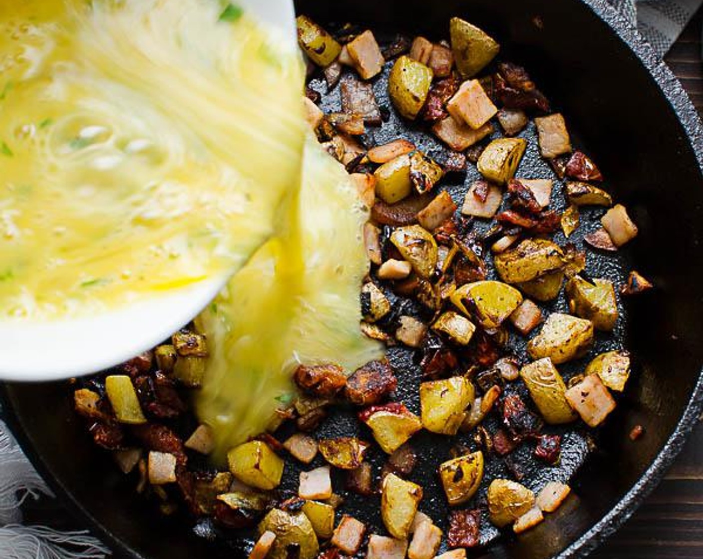 step 6 Spread the ingredients in the skillet into an even layer. Pour the egg mixture into the skillet and top with mozzarella cheese. Cook on top of the stove until the bottom of the frittata is set but the eggs on top are still uncooked for about 2 minutes.