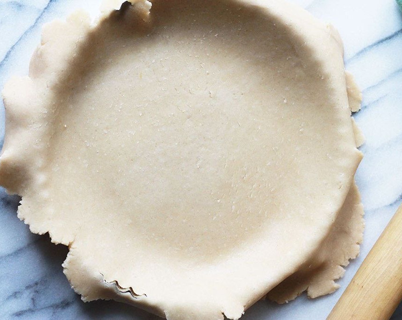 step 7 Drape the rolled dough over your rolling pin and transfer to tart pan. Gently pat the overhang in around the bottom of the pan and trim off the remaining overhang.