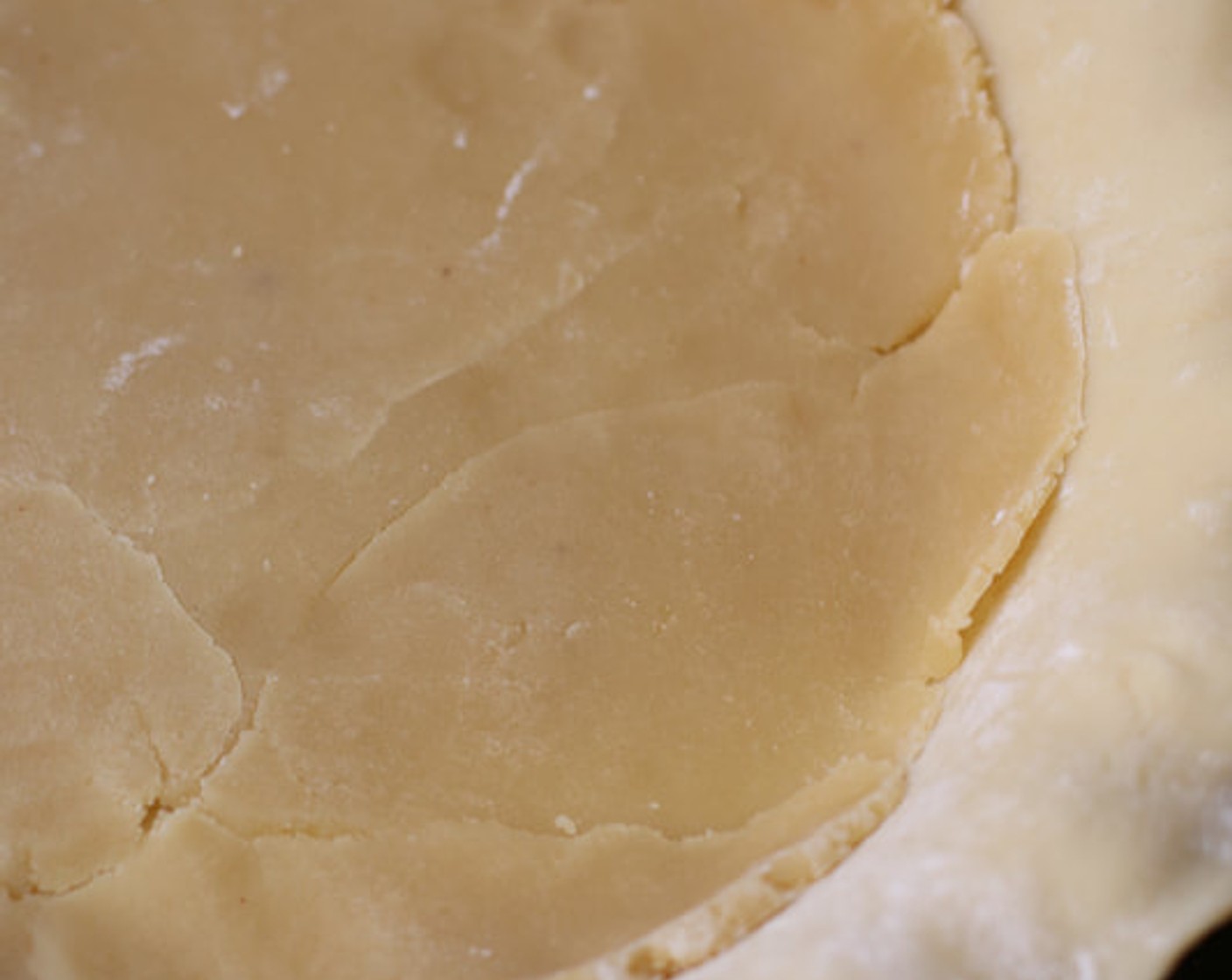 step 6 Unwrap the Almond Paste (1/2 cup). With your rolling pin and/or fingers, flatten half of it out into a 9-inch disc to fit snug into the bottom of the pie crust.  Gently place on top of the pie crust.