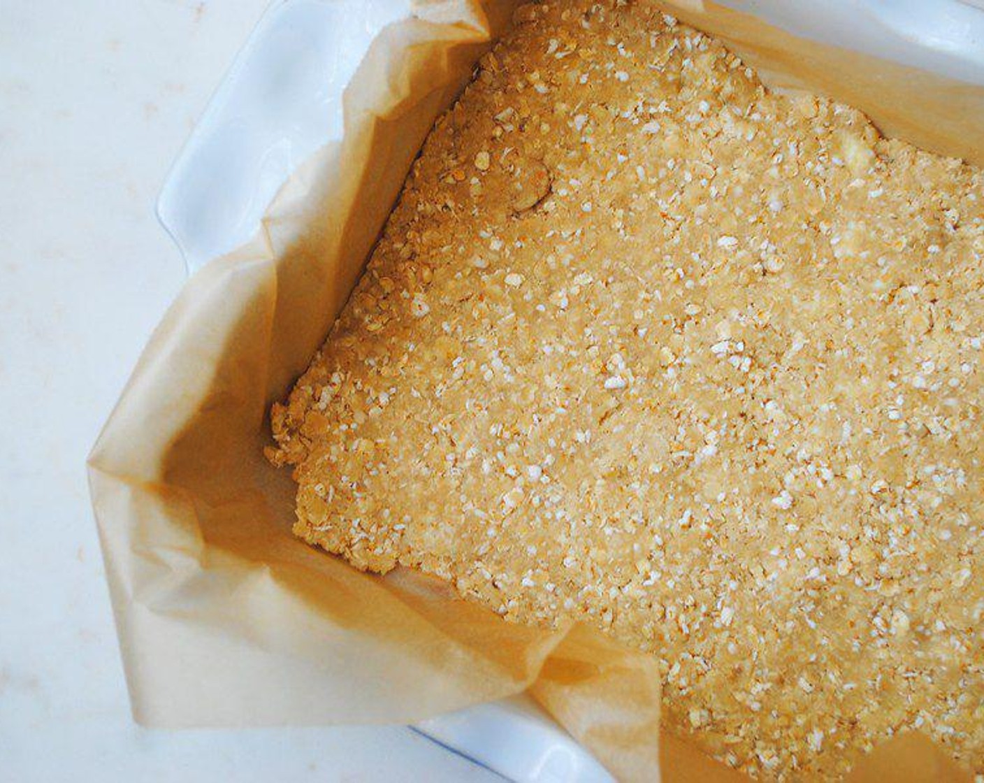 step 4 Place piece of parchment paper into a 9"x13 " glass baking dish. Spread rest of the mixture into bottom of the dish, pressing into the corners.